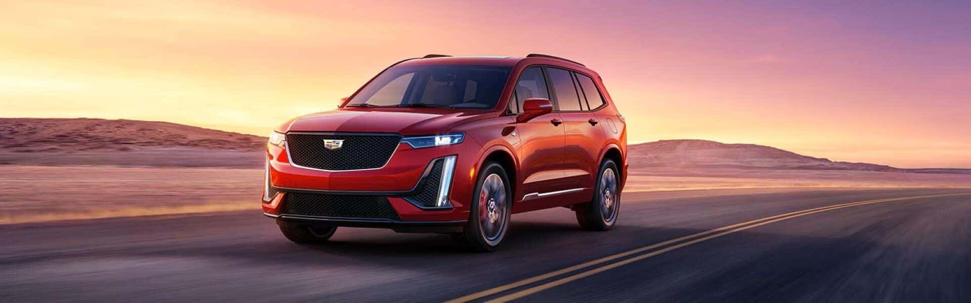 2024 Cadillac XT6 Luxury Mid-Size SUV Driving Down The Road Banner