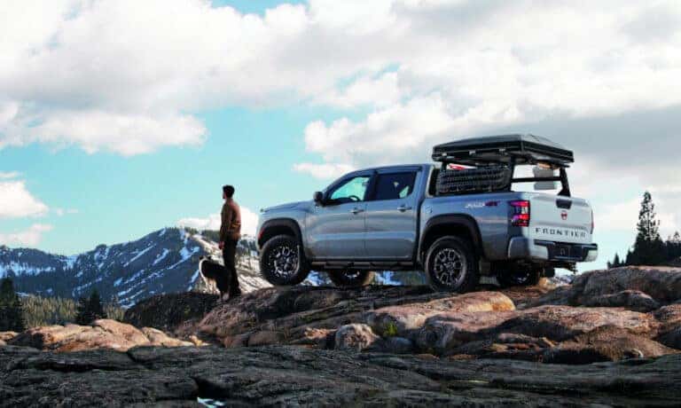 2022 Nissan Frontier parked in the mountains with a man and a dog