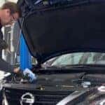 Nissan Technician Performing Oil Change on Car