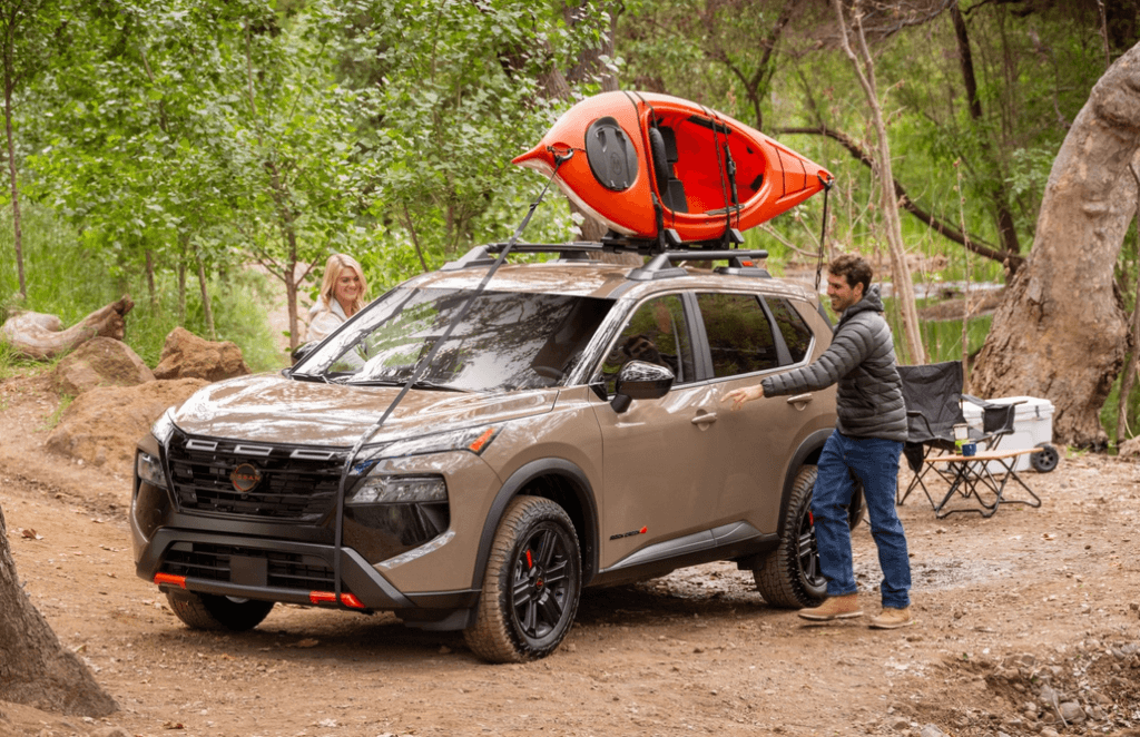 Happy Couple Getting into Their Nissan Rogue Rock Creek Edition Parked Front 3/4 View at a Campsite