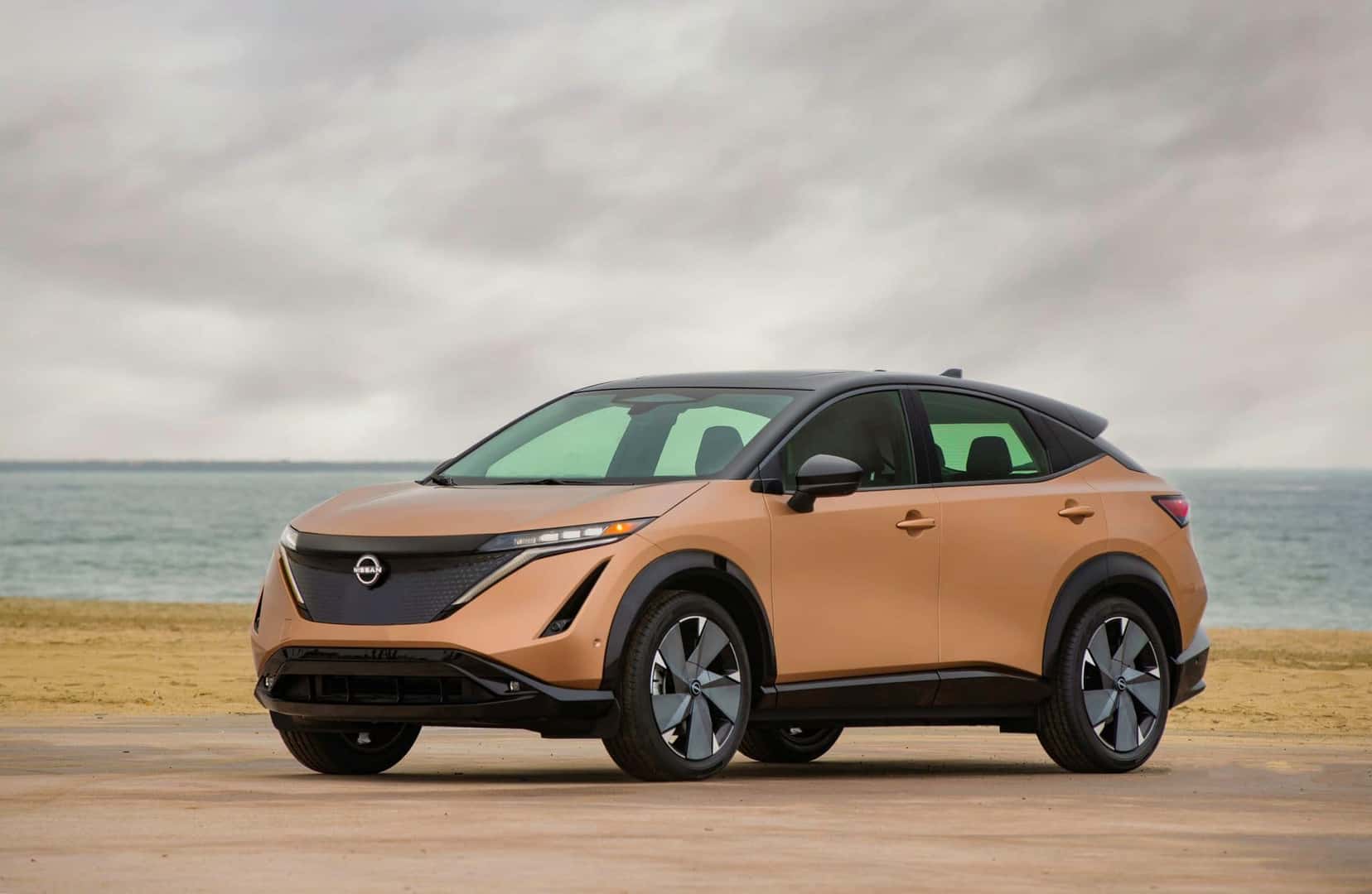 The Distinguished Nissan Ariya, Parked On The Beach, Stormy Clouds In The Background