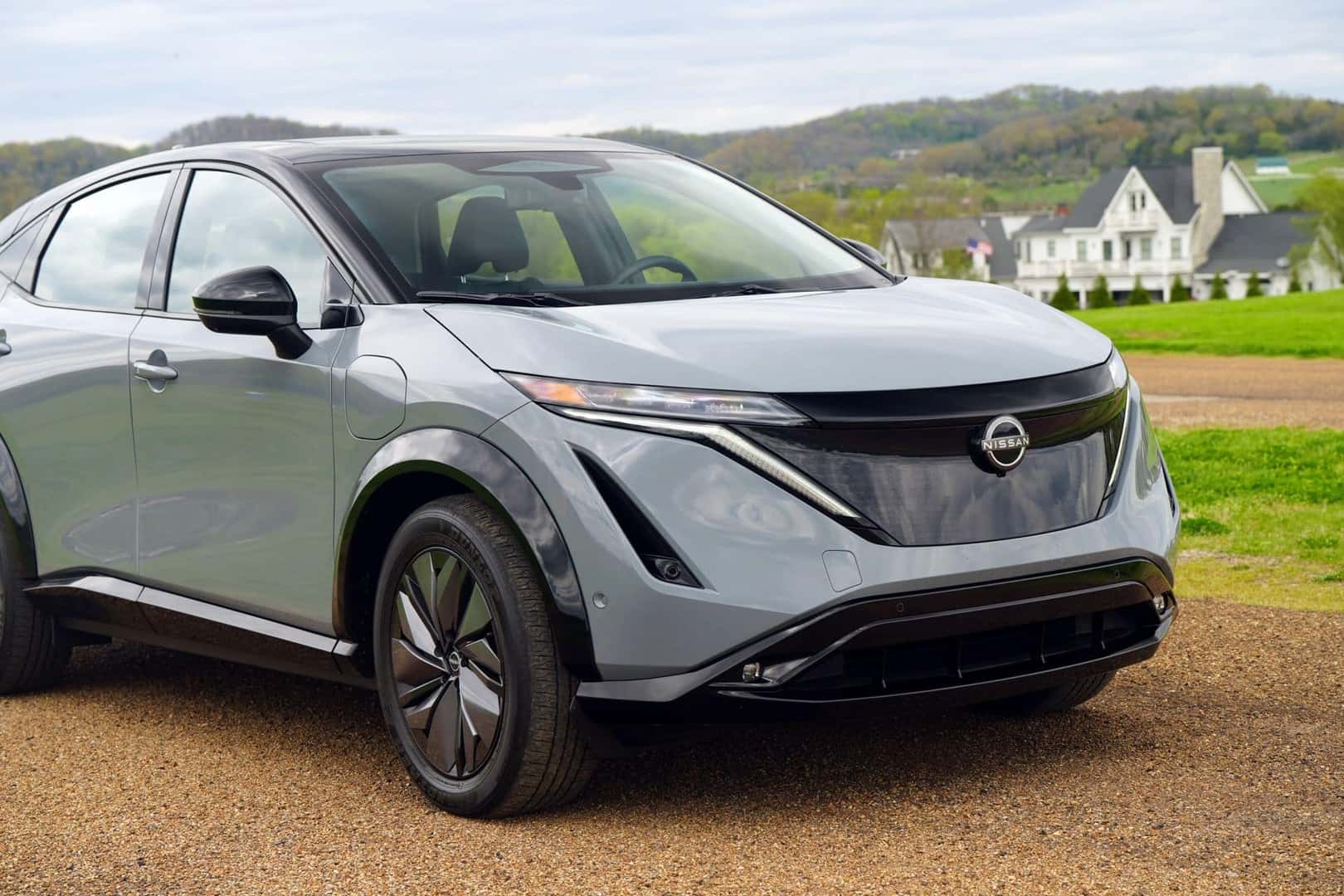 The Nissan Ariya EV Cruising In The Country, Passing Gorgeous And Elaborate Country Houses