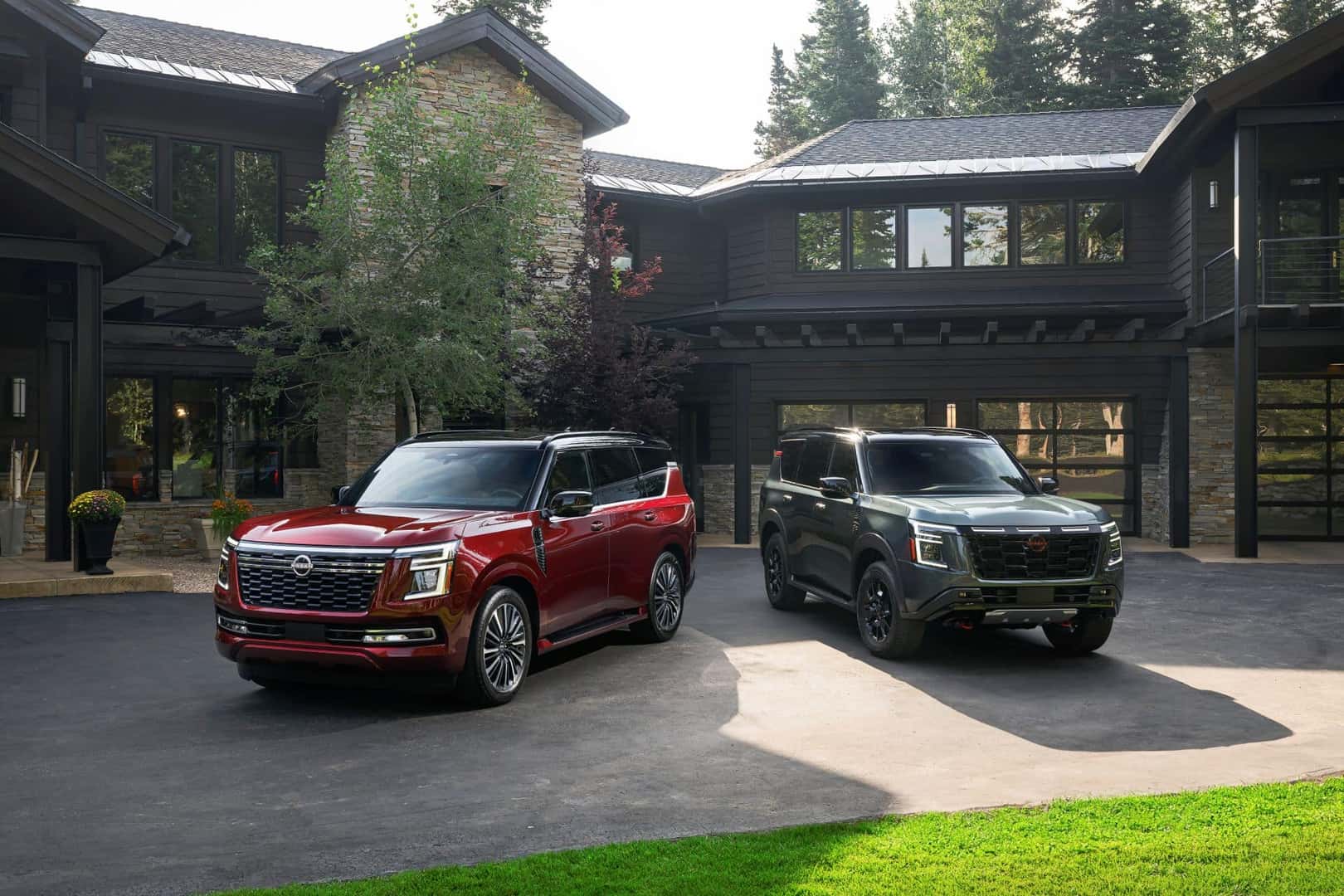 Two Nissan Armadas Parked In Front Of A Beautiful Mansion