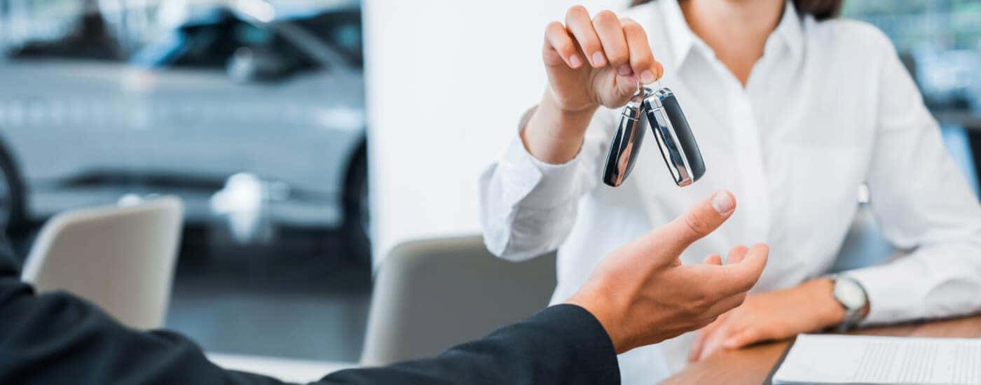 Car dealer giving car key to buyer