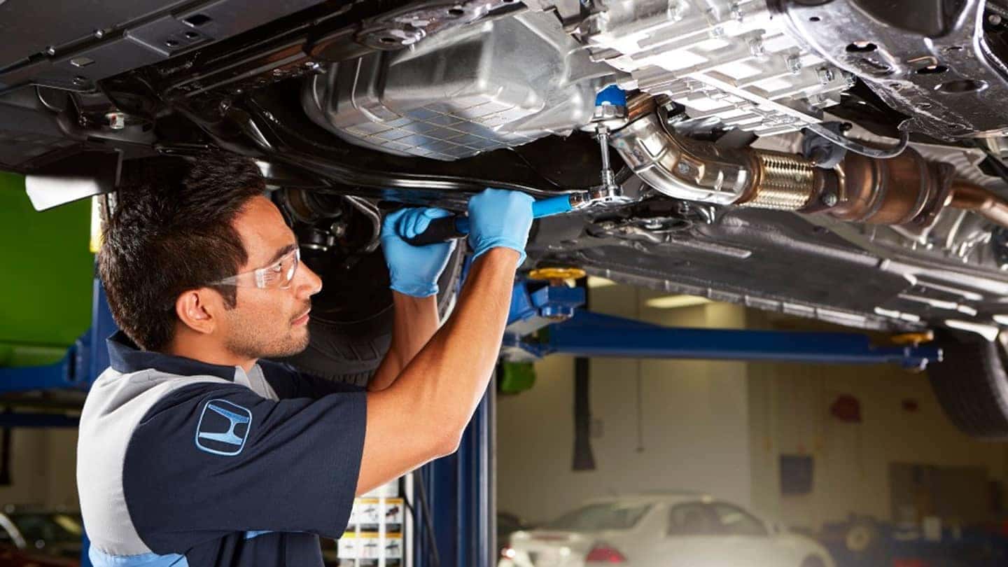 Honda service tech working on ca up on lift
