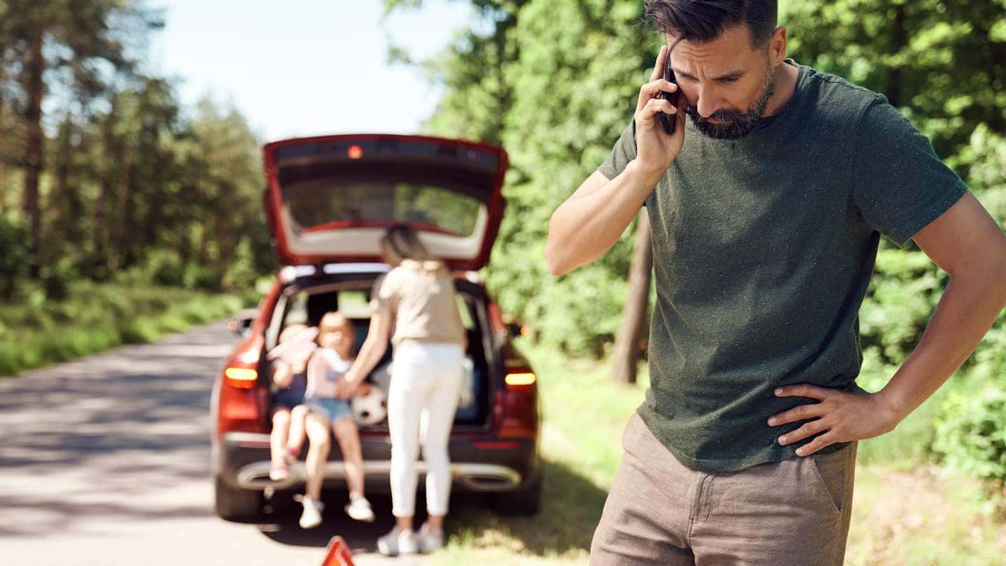 man on phone after car breaksdown