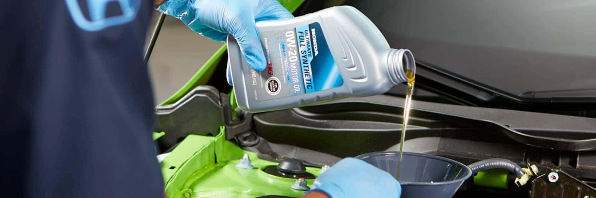Honda service tech pouring oil for oil change