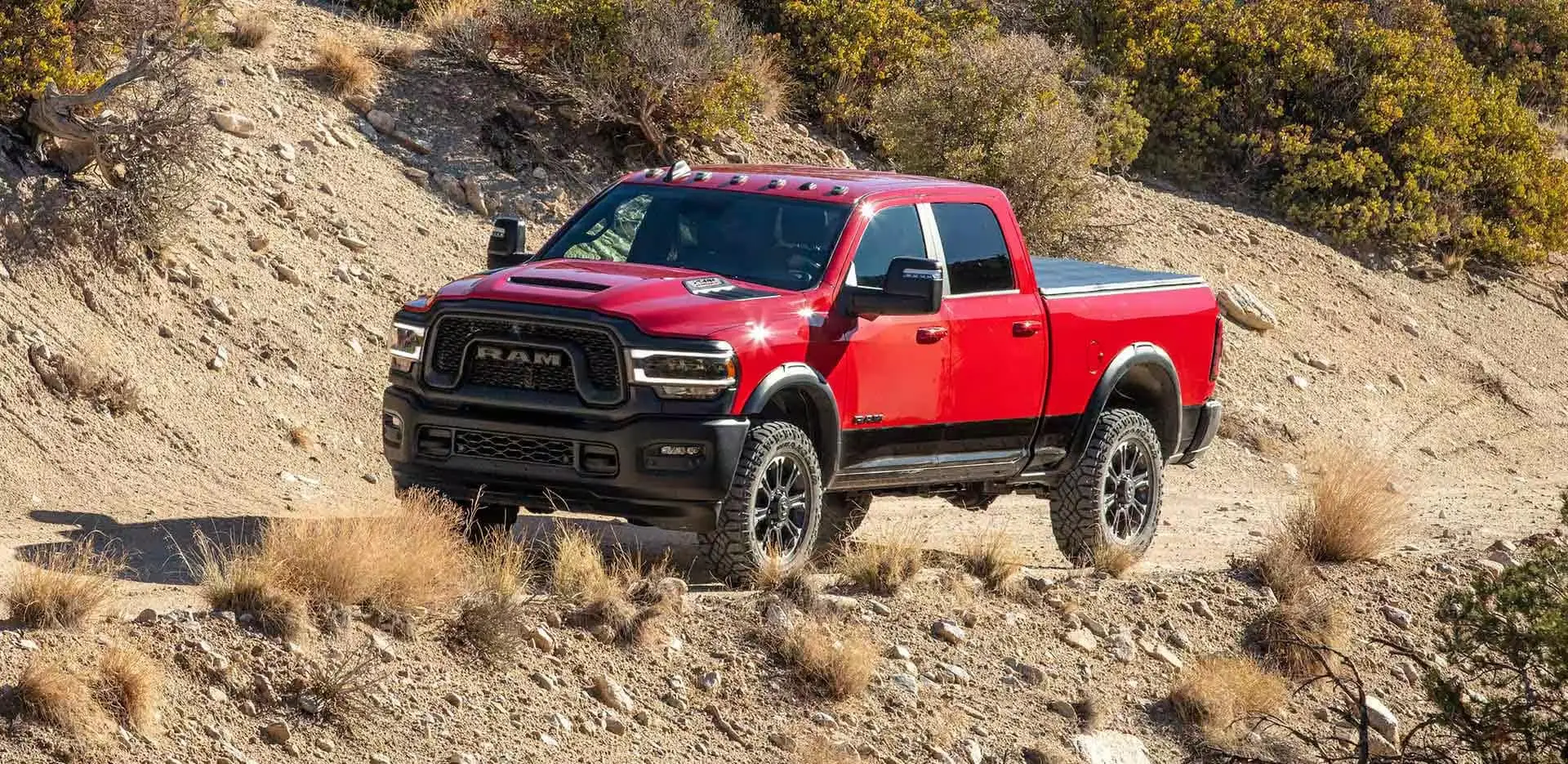 a red truck driving on a dirt road