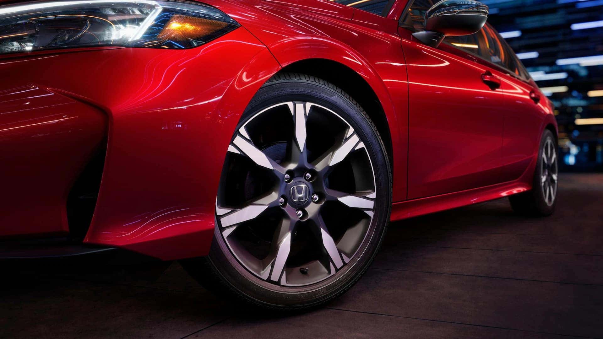 the front drivers side view showcasing the front tire of a red honda civic sedan at night