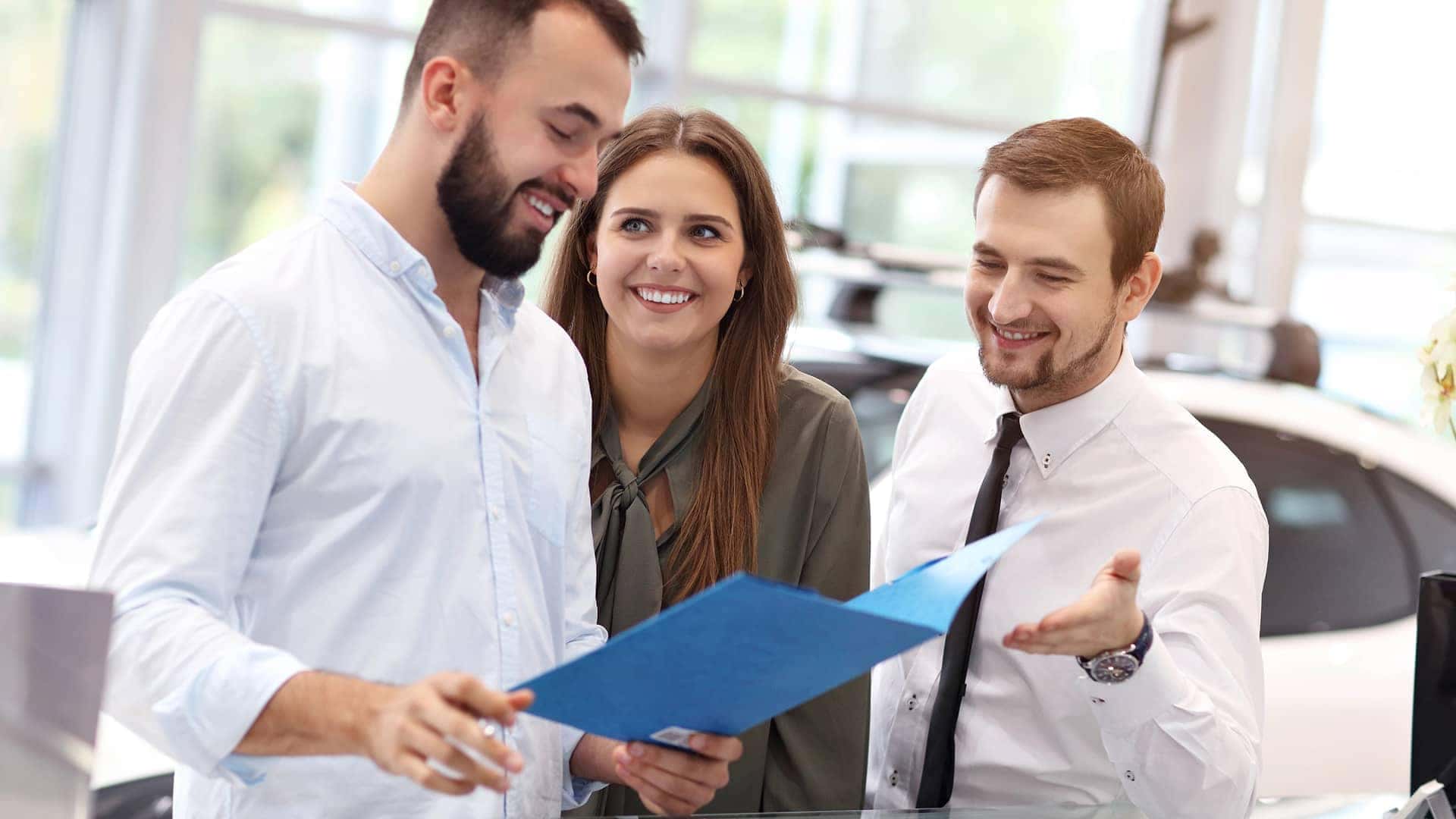 customers at dealership with paperwork