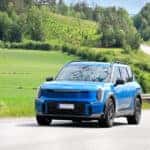 Blue 2024 Kia Ev9 driving on a country road
