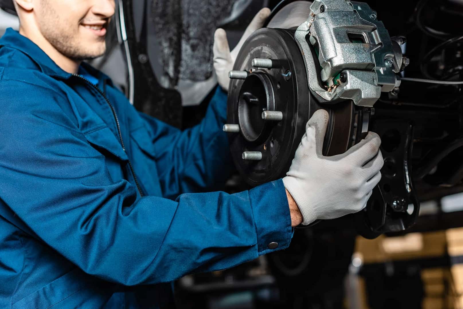 Mechanic working on vehicle breaks