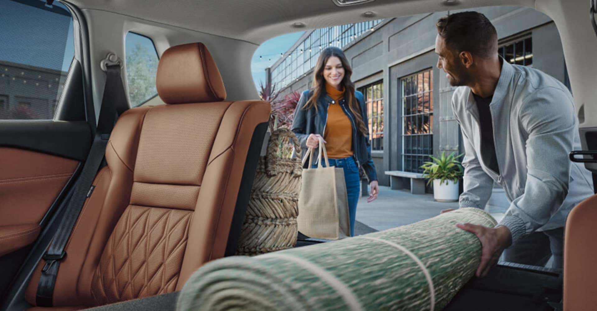 Person loading large material in back of 2025 Nissan Rogue