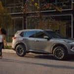 Person walking across the street next to their parked nissan rogue