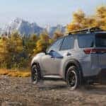 2026 nissan pathfinder rear three quarter view driving dirt