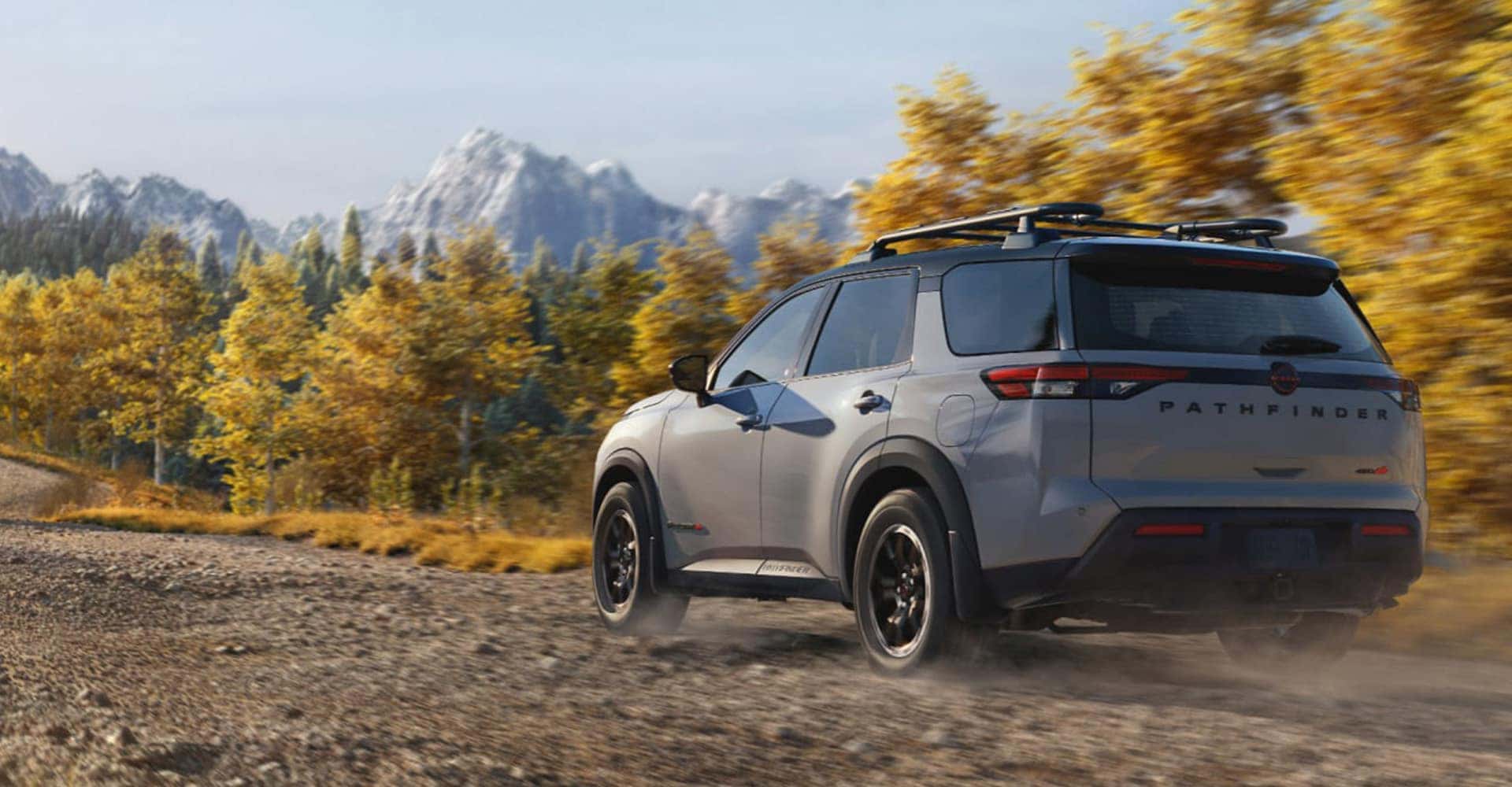 2026 nissan pathfinder rear three quarter view driving dirt