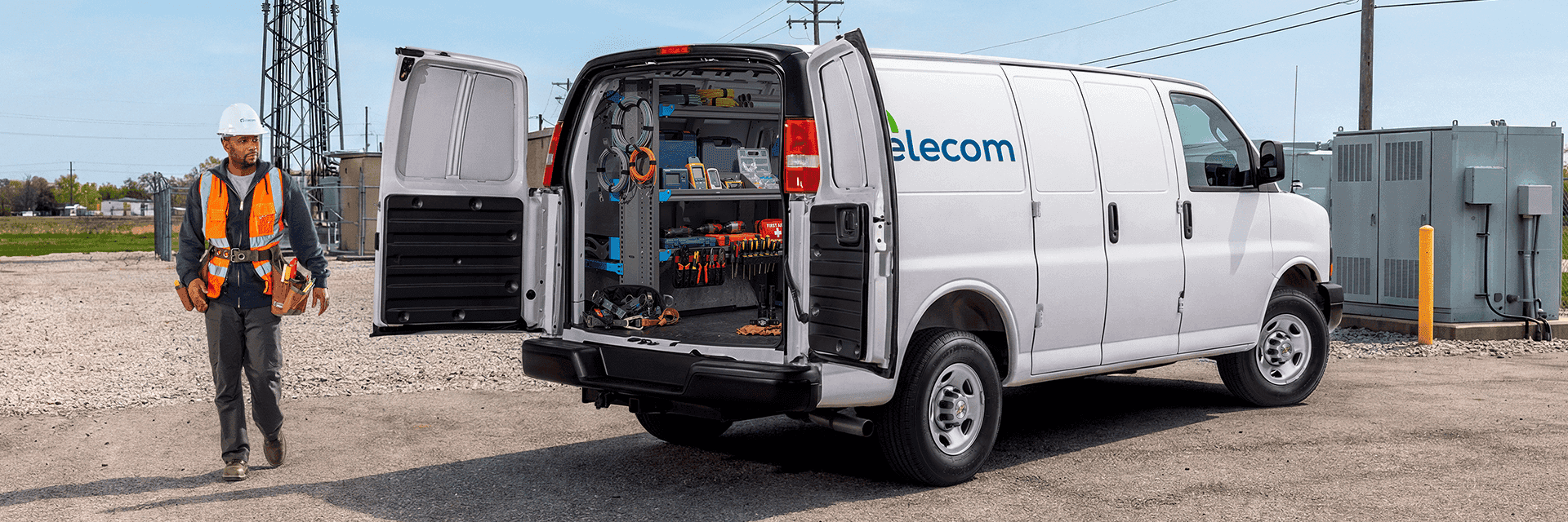 Telecom company employee standing next to his Chevy work van