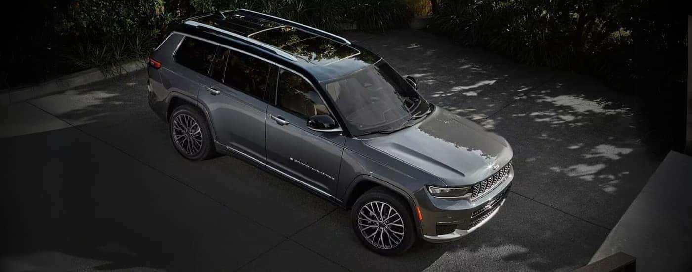 A grey 2024 Jeep Grand Cherokee is parked on pavement.