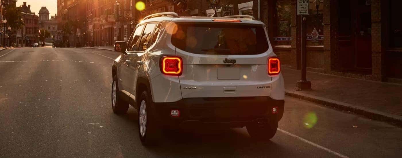 A white 2023 Jeep Renegade Limited is driving at sunset.