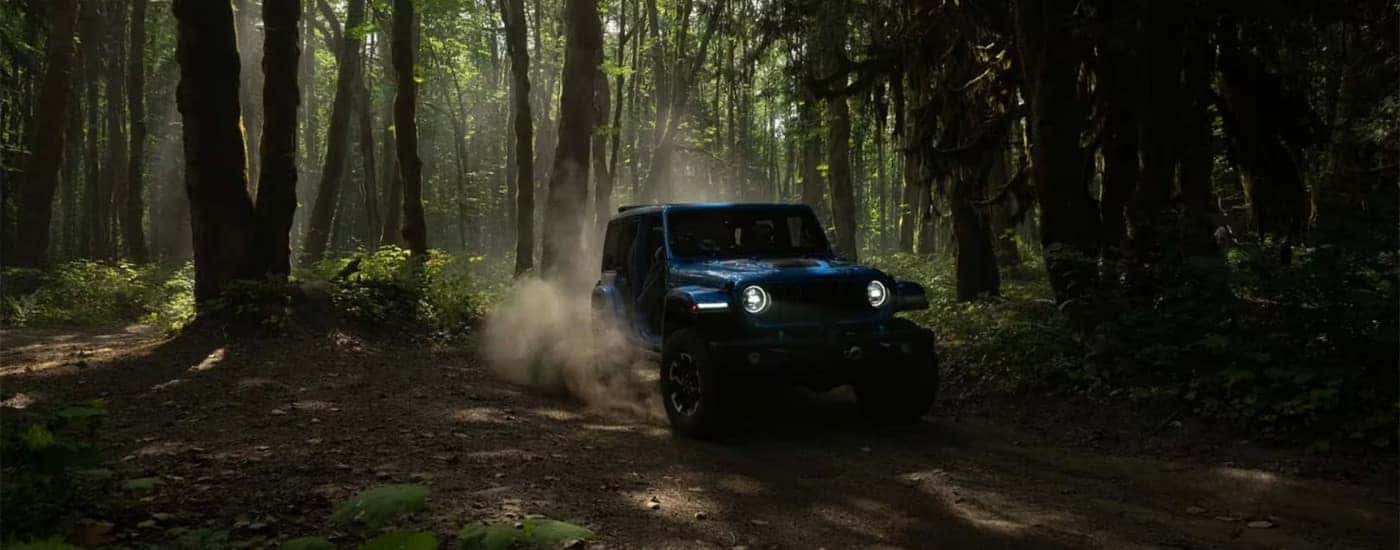 A blue 2024 Jeep Wrangler 4xe is driving to a Jeep dealer near Monroeville.