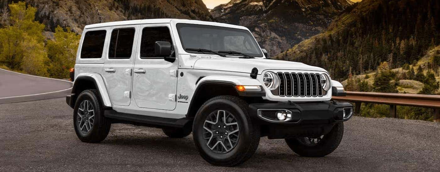 A white 2025 Jeep Wrangler Sport parked at a Jeep dealer near Murrysville.
