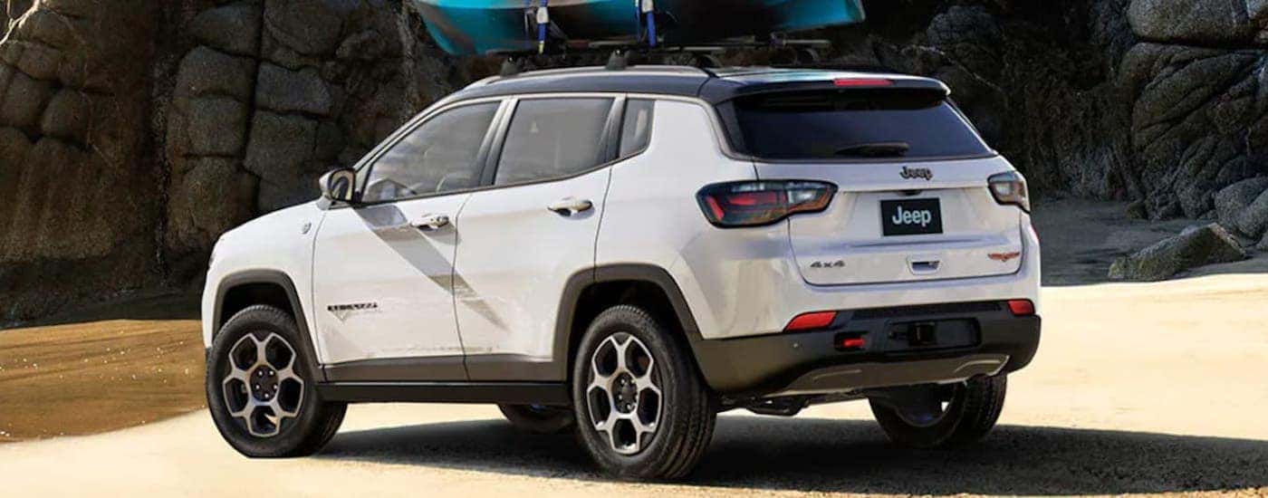 Rear view of a white 2022 Jeep Compass parked near a shore.