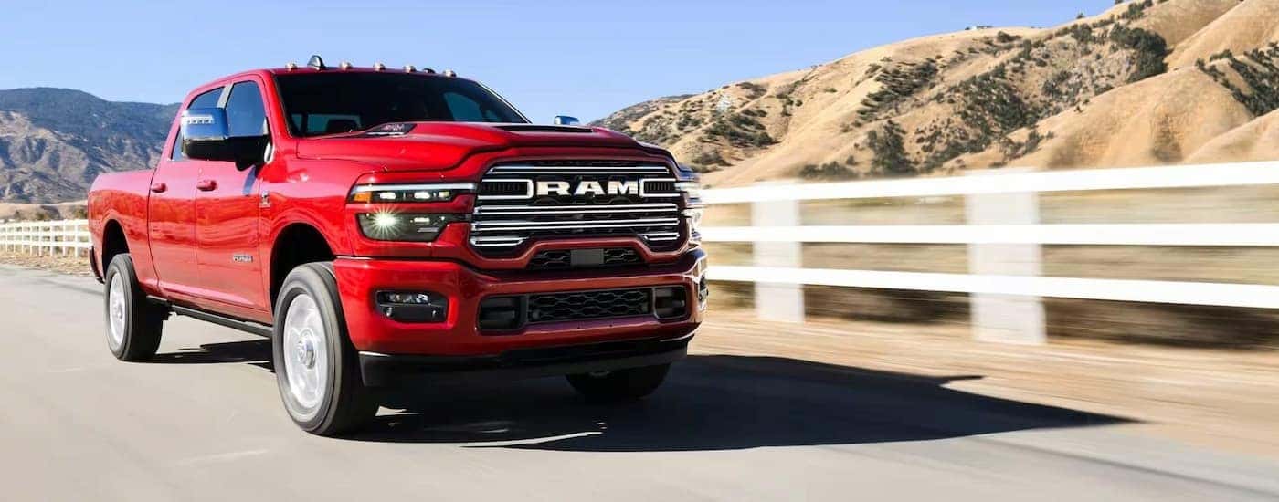 A red 2025 RAM 2500 driving to a Ram dealer near Monroeville.