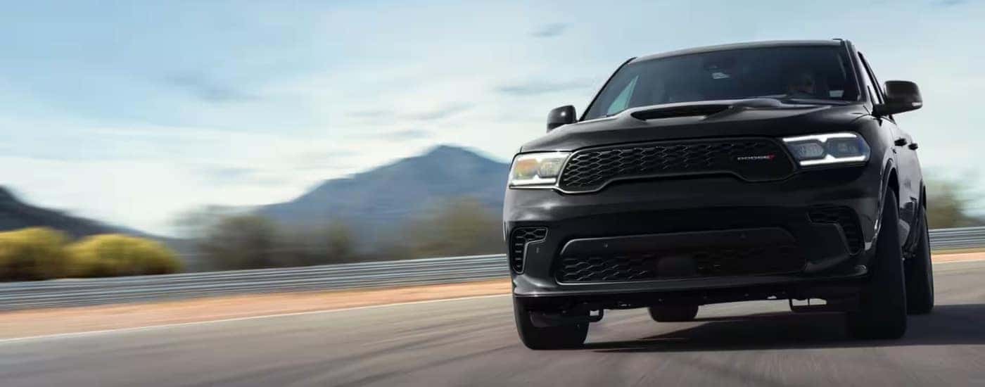 A black 2023 used Dodge Durango for sale driving on an open road.