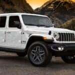A white 2025 Jeep Wrangler parked off-road