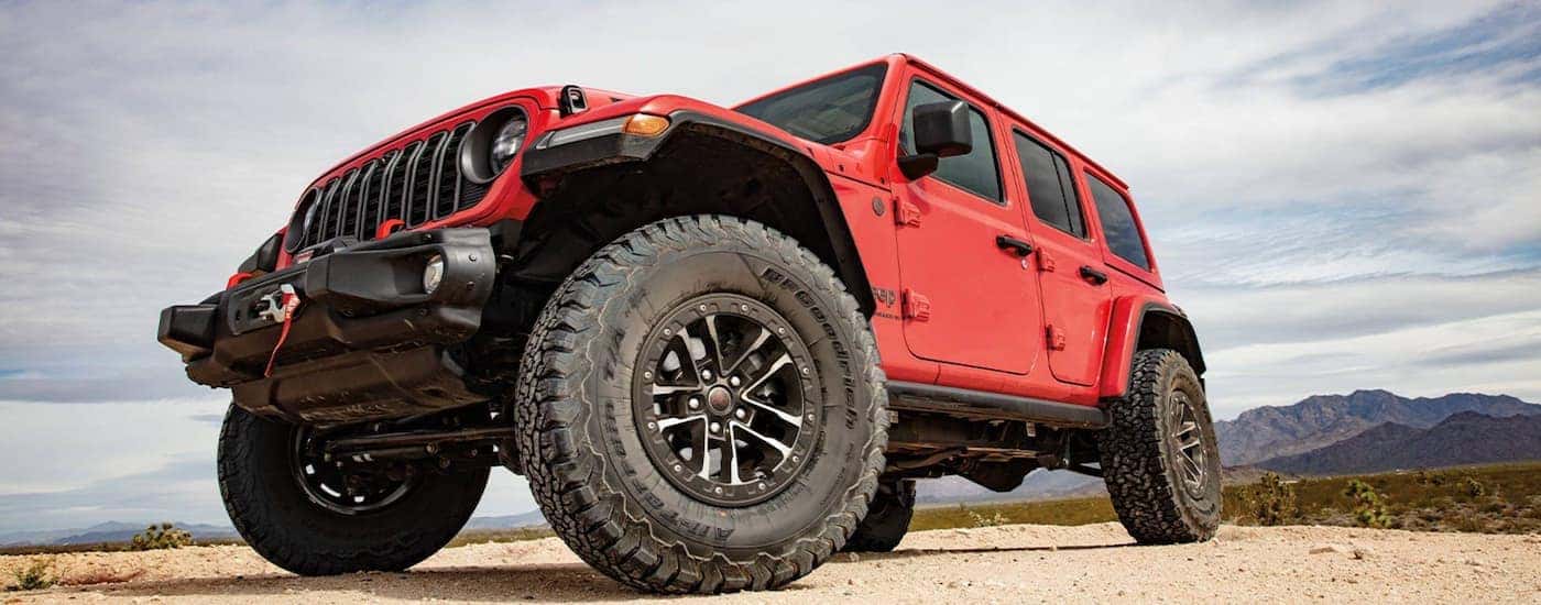 Red 2025 Jeep Wrangler for sale parked off-road. 