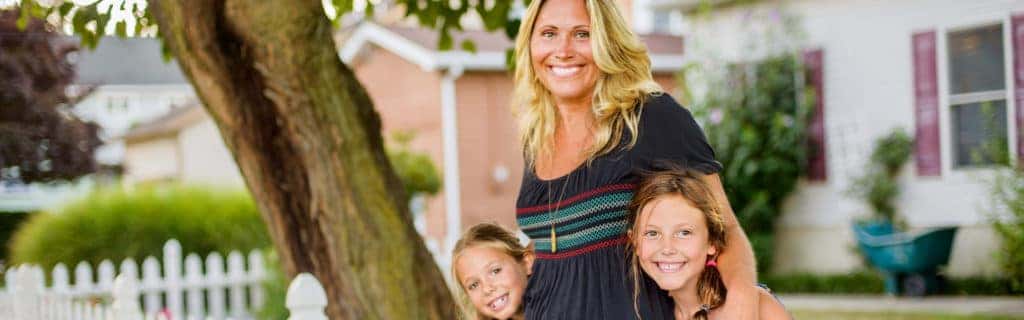 Washington Honda is a Honda Dealership in Washington near Peters Township PA | A small town Mom and her two kids standing in front of their home