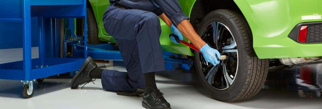How to check your tires' health at Washington Honda of Washington | Mechanic on knee checking tire