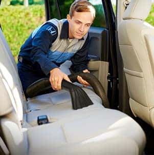 How to prepare your Honda for the winter season in Washington, PA at Washington Honda | Mechanic vacuums back seats of car