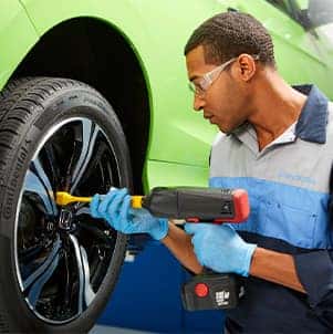 How to prepare your Honda for the winter season in Washington, PA at Washington Honda | Mechanic unbolts tire