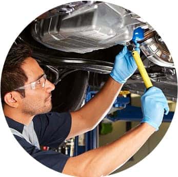 Difference between synthetic oil & conventional oil at Washington Honda | Honda Technician under the car takes out the oil filter