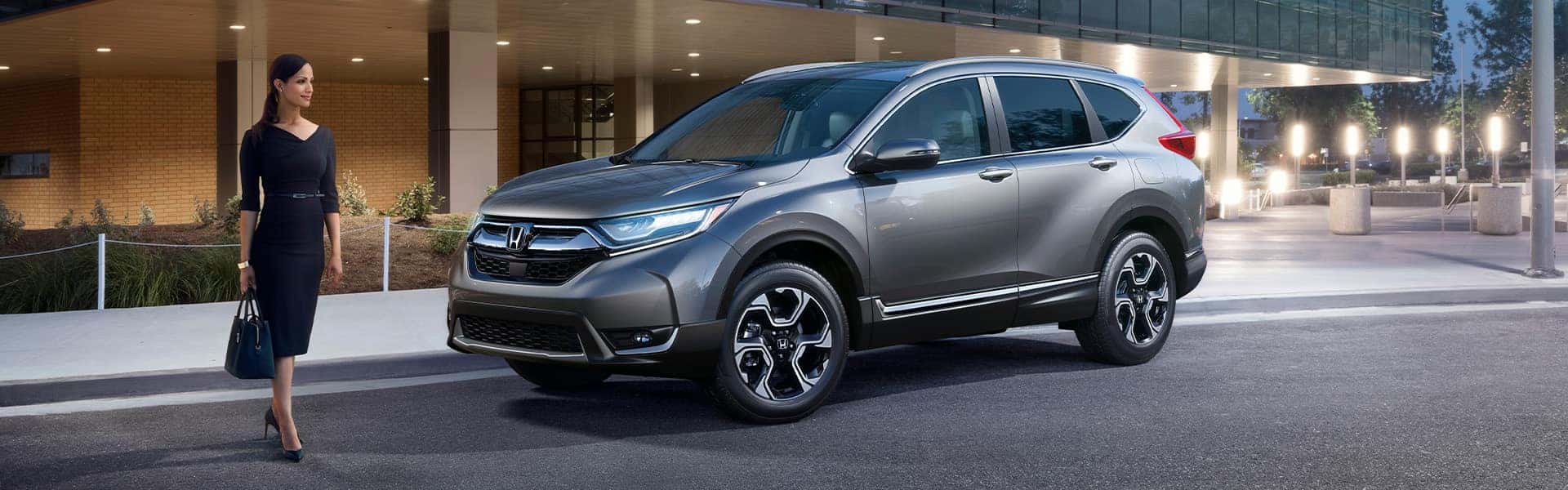 Things to Check When Buying a Used Car | Washington Honda | Silver Used Honda CR-V Street Parked in the City Next to Office Building