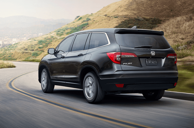 The 2022 Honda Pilot vs The 2022 Subaru Ascent at Washington Honda | Rear view of Black Honda Pilot driving down the road
