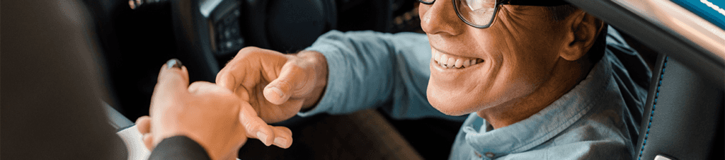 Defining GAP Insurance at Washington Honda in Washington, PA | Man smiling in his new car while another person is about to shake his hand