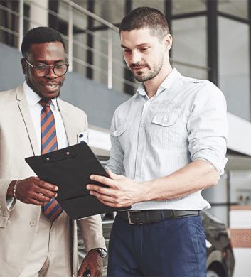 Defining GAP Insurance at Washington Honda in Washington, PA | Sales person talking to another man and showing him a clipboard with important information on it