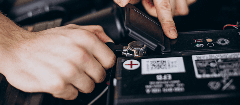 Everything You Need to Know about Your Car Battery at Washington Honda | Close up of a person lifting the lid of car battery
