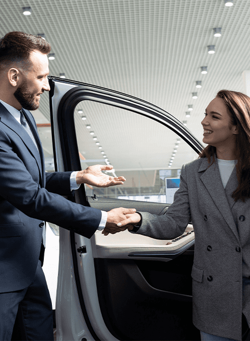 Leasing versus Buying a Honda at Washington Honda in Washington, PA | Sales person shaking hands with a woman getting out of a car she just test drove 