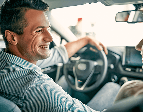 Leasing versus Buying a Honda at Washington Honda in Washington, PA | Man sitting in the drivers seat of a car while smiling next to someone 